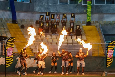 Performers with fire on the baseball field as fans hold up Filthy Friday letters in the stands